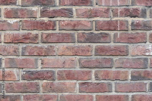 Fragment of the wall of an old building made of baked brick in natural light. Close-up. Texture. Background.