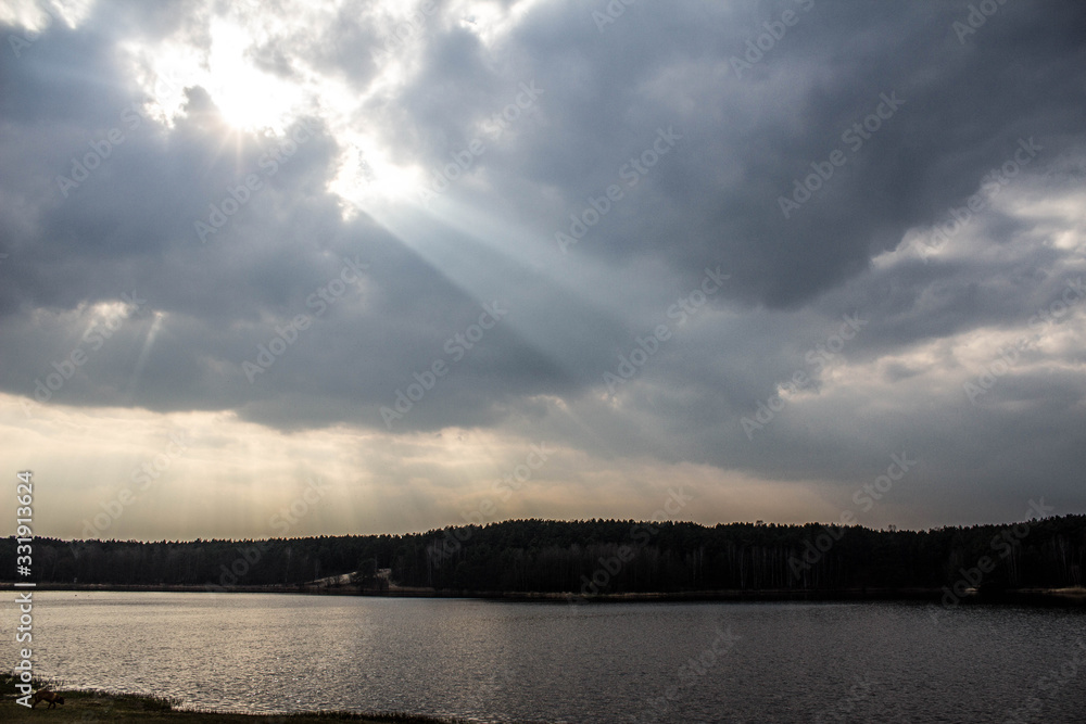 Bright sky with sunbeams over the lake. Beautiful landscape.