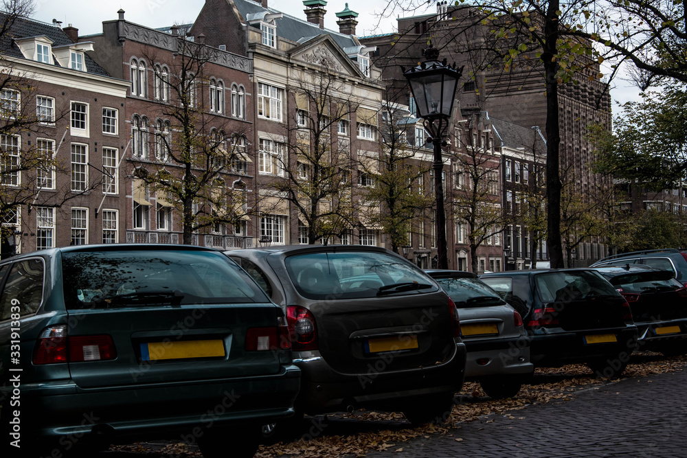 Cityscape of Amsterdam. Dutch city architecture. Modern exterior of buildings. Parking cars.