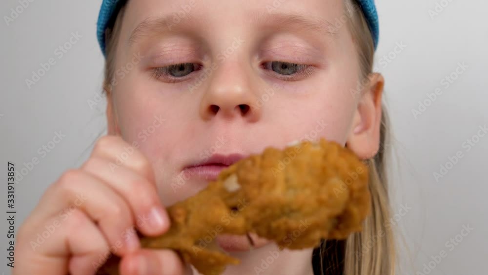 Hungry Child Appetising Eating a Chicken Leg Close-up.The Fast- Food Concept Hungry Child Appetising Eating a Chicken Leg Close-up.The Fast- Food Concept