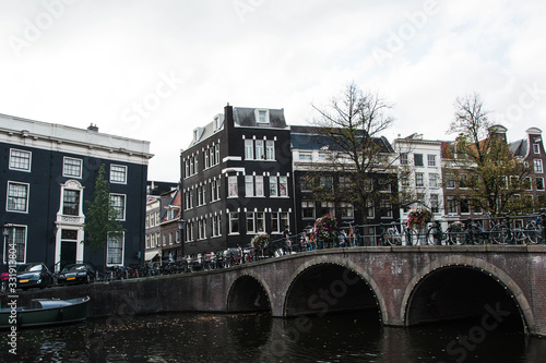 Cityscape of Amsterdam. Dutch city architecture. Modern exterior of buildings. Bridge over canal.