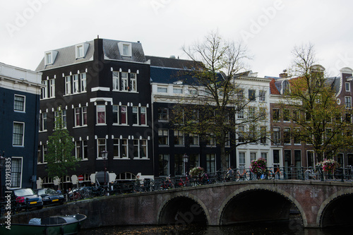 Cityscape of Amsterdam. Dutch city architecture. Modern exterior of buildings. Bridge over canal.