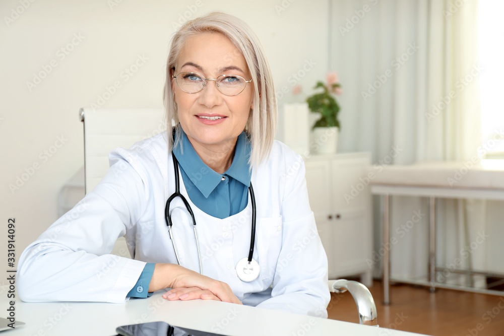 Portrait of mature female doctor in white coat at workplace Portrait of mature female doctor in white coat at workplace