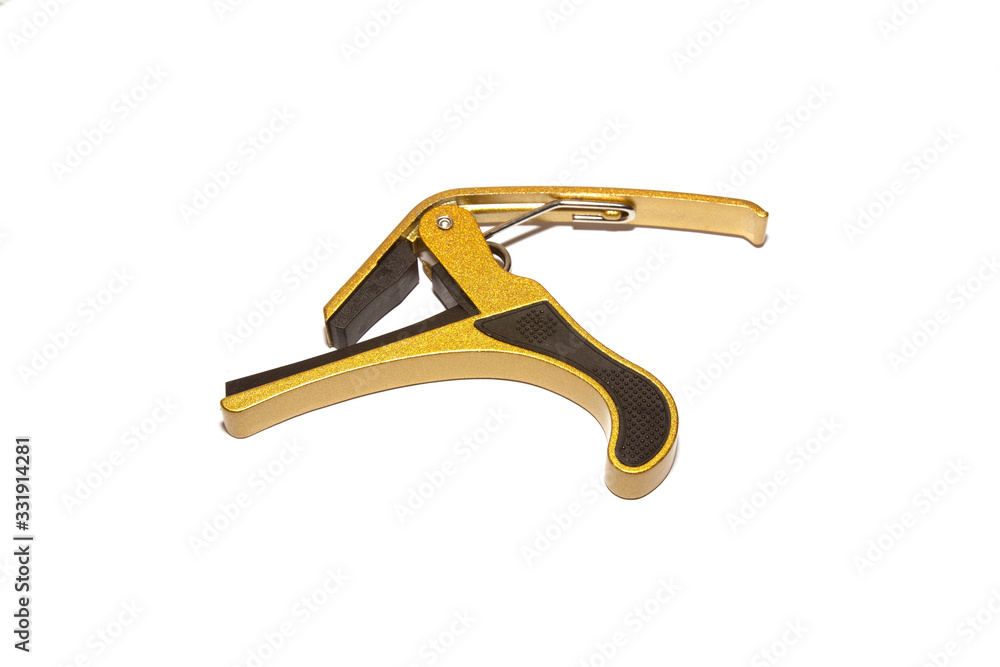Golden guitar capo isolated on white background Golden guitar capo isolated on white background