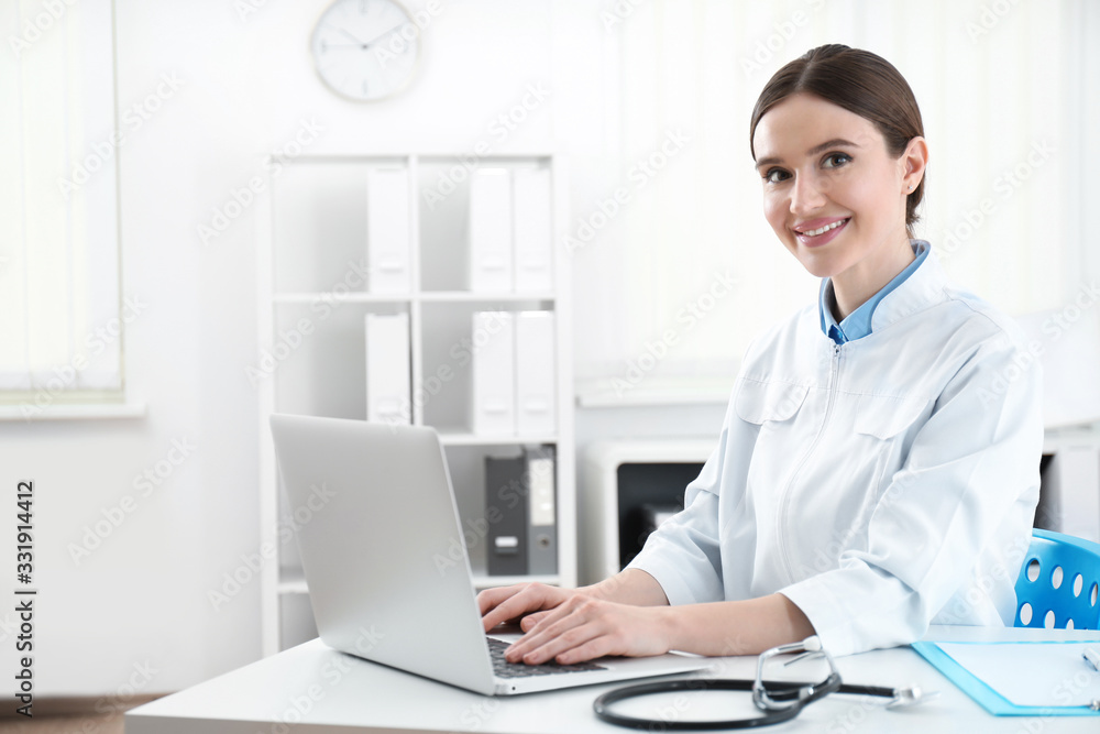 Portrait of young female doctor in white coat at workplace Portrait of young female doctor in white coat at workplace