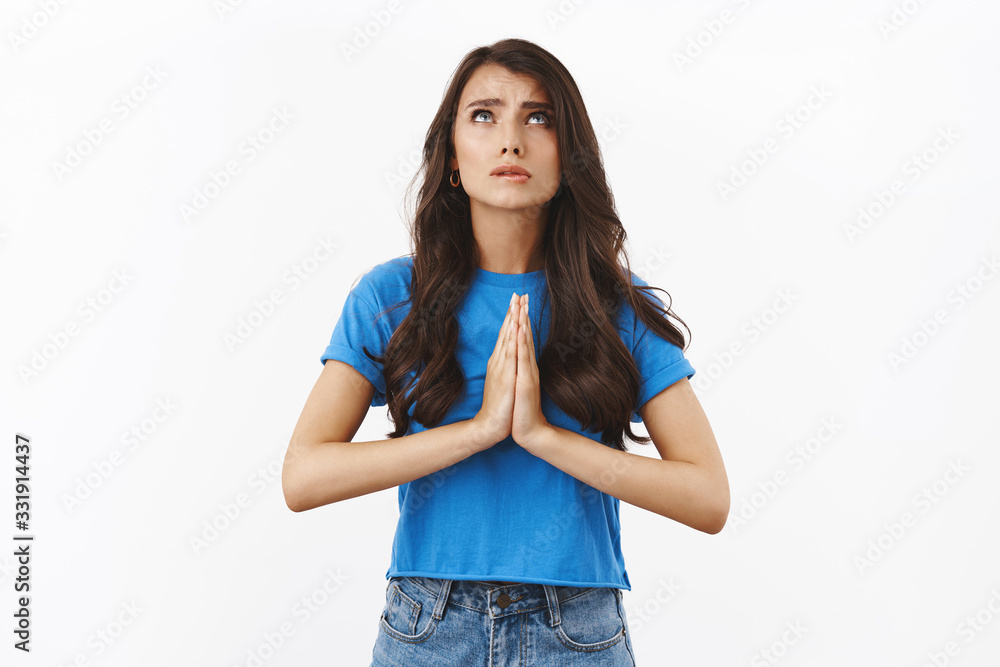 Dear lord make my dream come true, please hear prayers. Worried supplicating brunette woman clasp hands together in pray, looking at sky frowning worried, standing white background Dear lord make my dream come true, please hear prayers. Worried supplicating brunette woman clasp hands together in pray, looking at sky frowning worried, standing white background