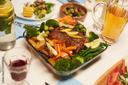 Image of roast meat with potatoes and vegetables served for dinner on the table