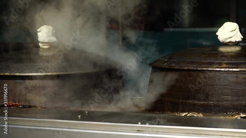 Traditional iron cooking pot boiling beef bone broth at Korean restaurant
