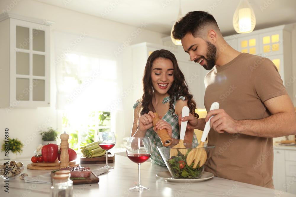 Lovely young couple cooking salad together in kitchen Lovely young couple cooking salad together in kitchen
