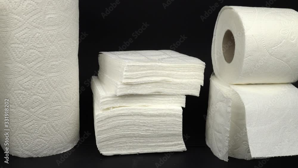 Rolls of white toilet paper, white paper napkins, and paper towels are