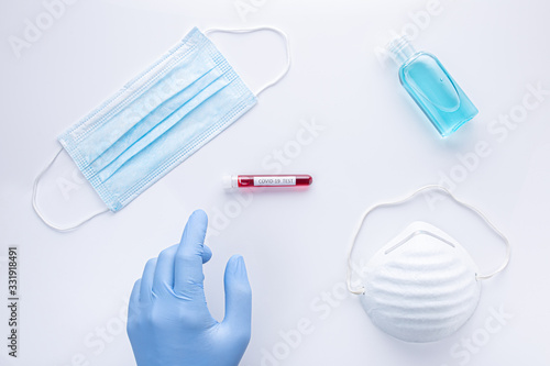 Material for the prevention of coronavirus, latex gloves, masks, hand sanitizing gel and test tube with blood sample. covid-19 and pandemic global concept .