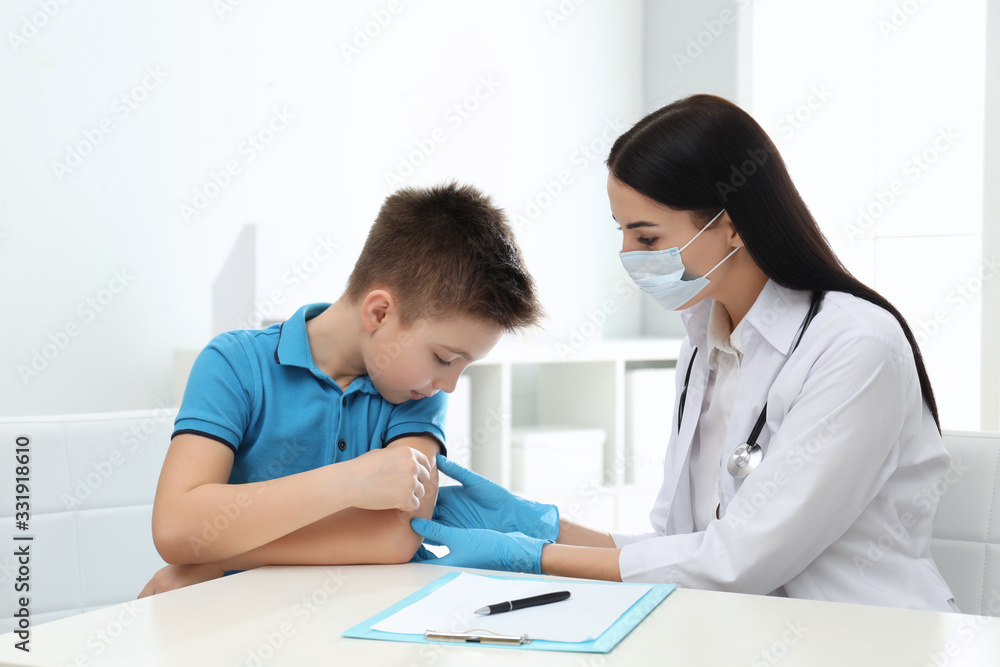 Fototapeta premium Doctor examining little patient before vaccination in clinic
