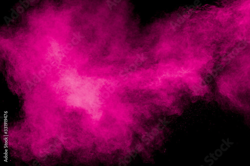 Abstract pink dust explosion on black background. Freeze motion of pink powder splash.