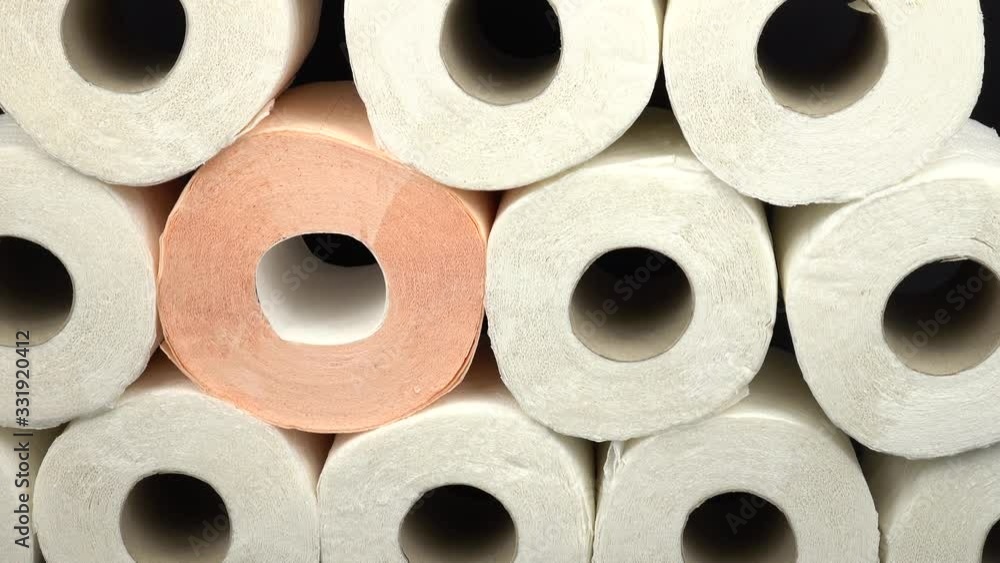 Rolls of white and pink toilet paper on a black wooden table, background Rolls of white and pink toilet paper on a black wooden table, background