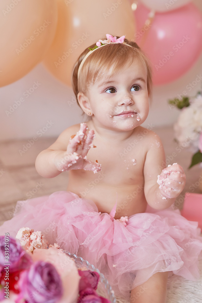 Smash cake party. Little cheerful birthday girl with first cake. Happy infant baby celebrating his first birthday. Decoration and photo zone for first year. One year baby celebration. Pink decor. Smash cake party. Little cheerful birthday girl with first cake. Happy infant baby celebrating his first birthday. Decoration and photo zone for first year. One year baby celebration. Pink decor.