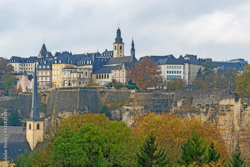 Detail of famous Luxembourg city line in November with Saint Michael Cathedral and yellow autumn trees, Luxembourg.
