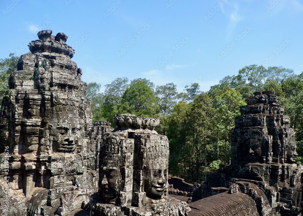 Ruins of Angkor, face tower of Bayon temple against blue sky, Angkor Wat, Cambodia