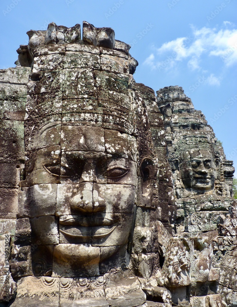 Ruins of Angkor, face tower of Bayon temple, closeup with blue sky, Angkor Wat, Cambodia Ruins of Angkor, face tower of Bayon temple, closeup with blue sky, Angkor Wat, Cambodia
