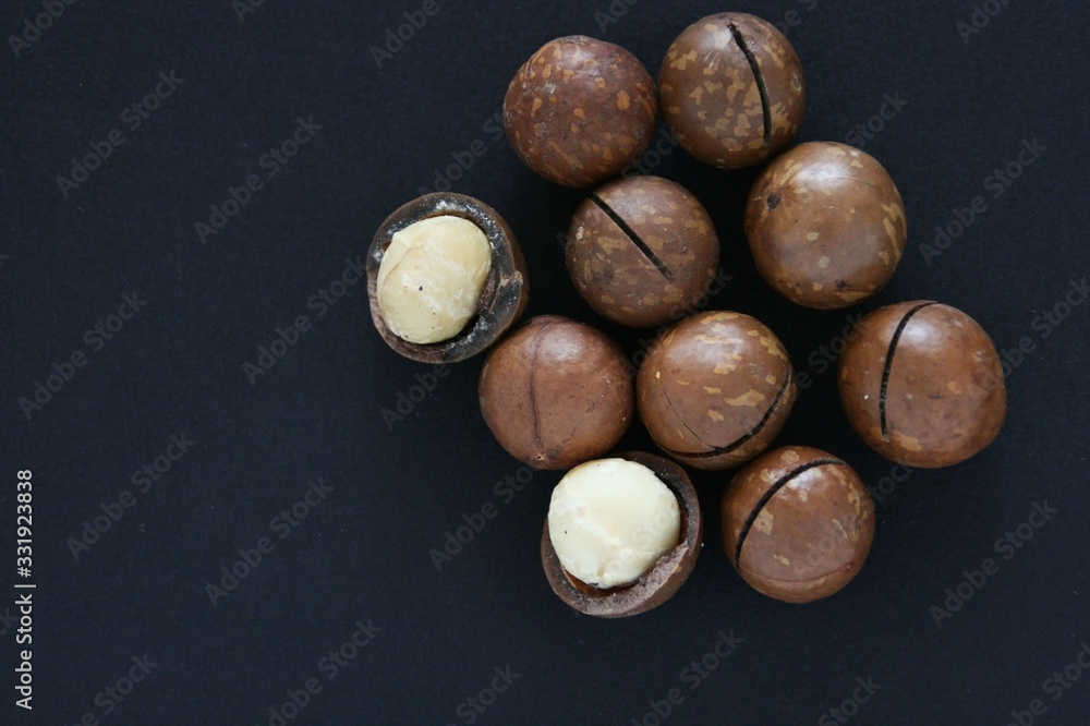 Macadamia nut  on dark background Natural background of macadam nuts