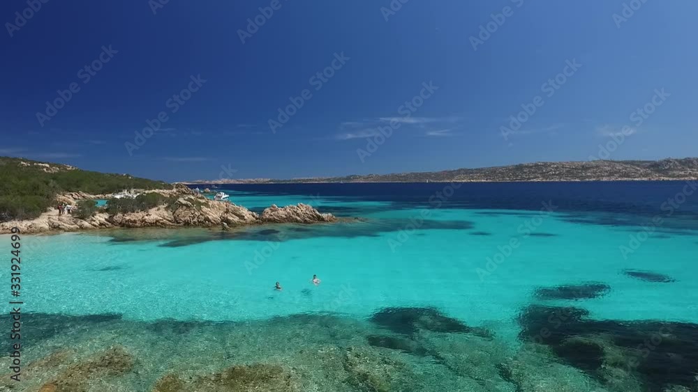 Scenic Sardinia coast of Maddalena archipelago with azure clear water. Boats and ships anchored, people swimming in sea. Aerial view. Scenic Sardinia coast of Maddalena archipelago with azure clear water. Boats and ships anchored, people swimming in sea. Aerial view.