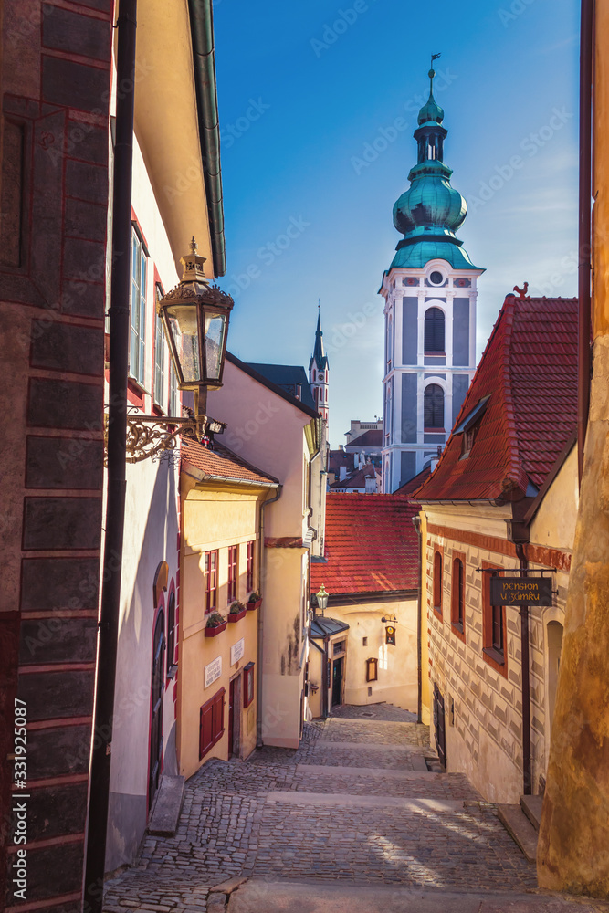 Obraz premium street of the old town - castle stairs, in the background the tower of the Church of St. Jost, Cesky Krumlov, Czech republic