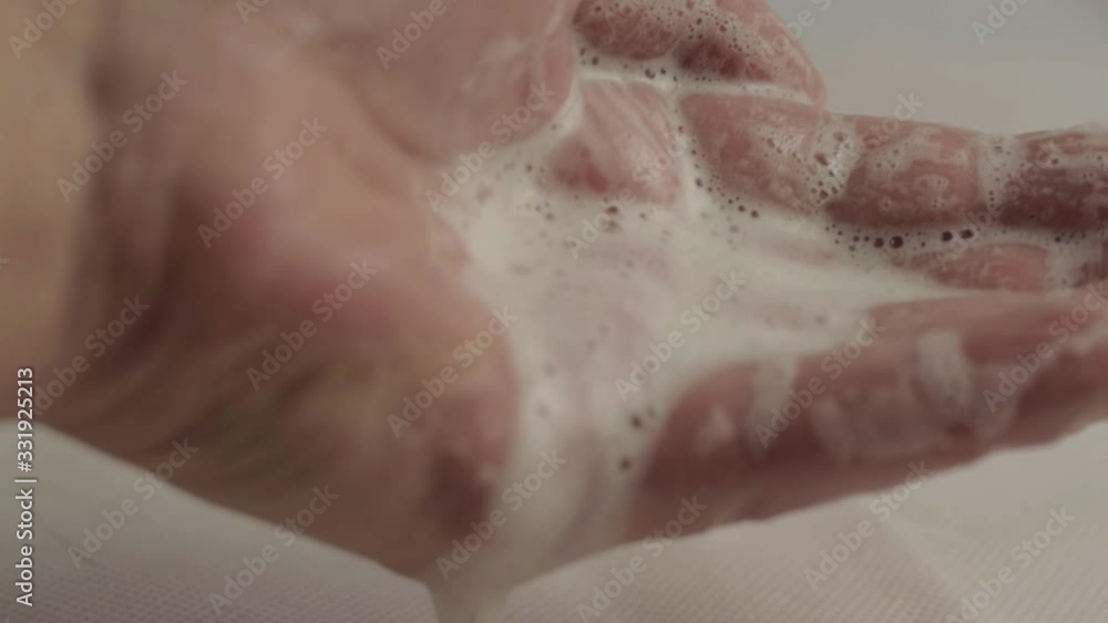 Hands with soapy water suds dropping macro shot Hands with soapy water suds dropping macro shot