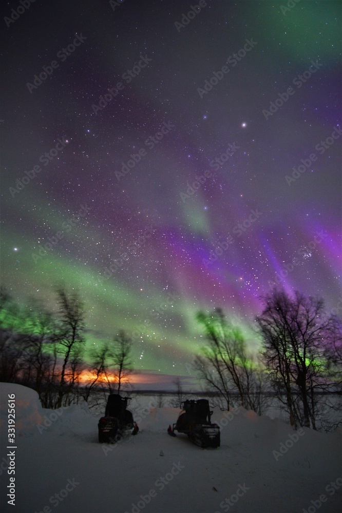 Northern lights in the night sky with winter landscape in Lapland Finland