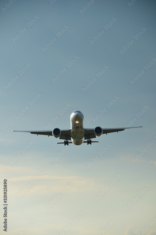 Silhouette of a plane landing in the summer with the setting sun Silhouette of a plane landing in the summer with the setting sun