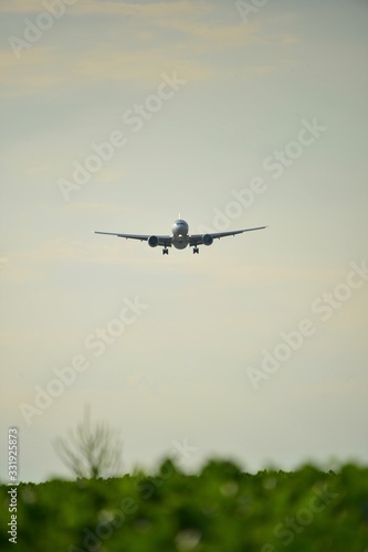 Silhouette of a plane landing in the summer with the setting sun