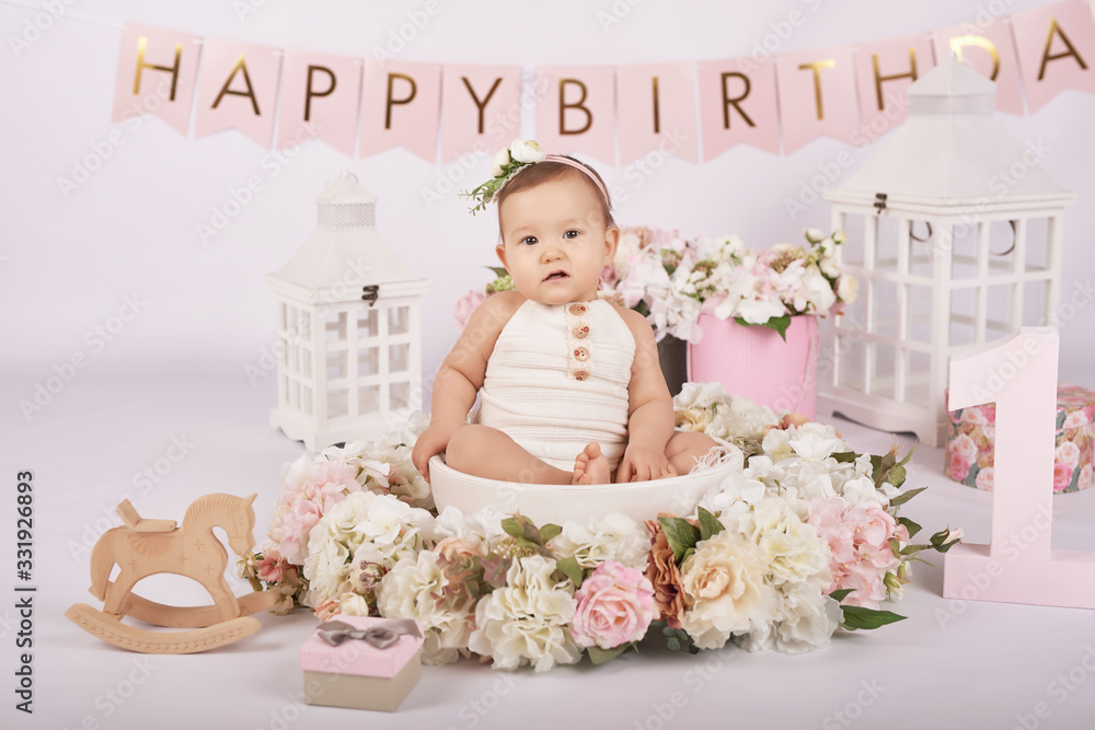 Smash cake party. Little cheerful birthday girl with first cake. Happy infant baby celebrating his first birthday. Decoration and photo zone for first year. One year baby celebration. Pink decor