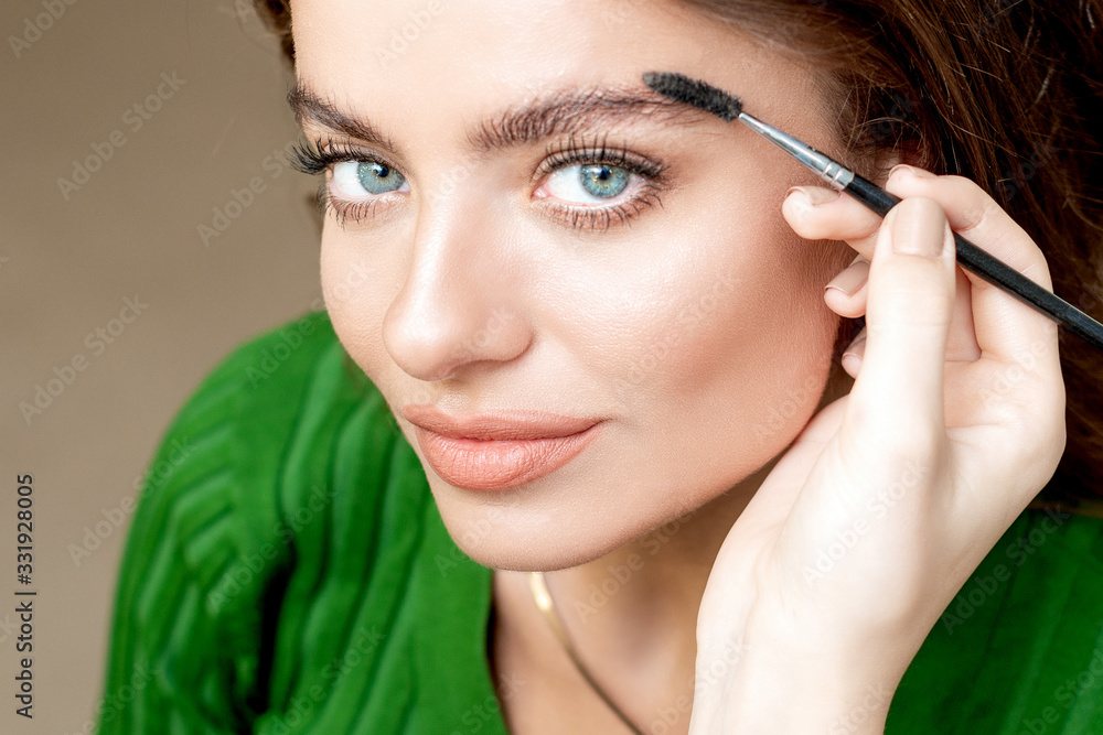 Combing eyebrows of woman.