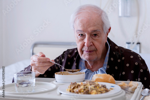 Elderly man hospitalized, eating in the room