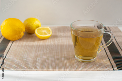 Cup of tea with on a background of lemons. Set of vitamins becouse of corona virus. photo