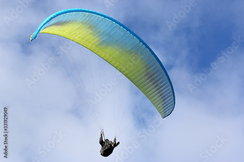 Paraglider flying wing in a blue sky 