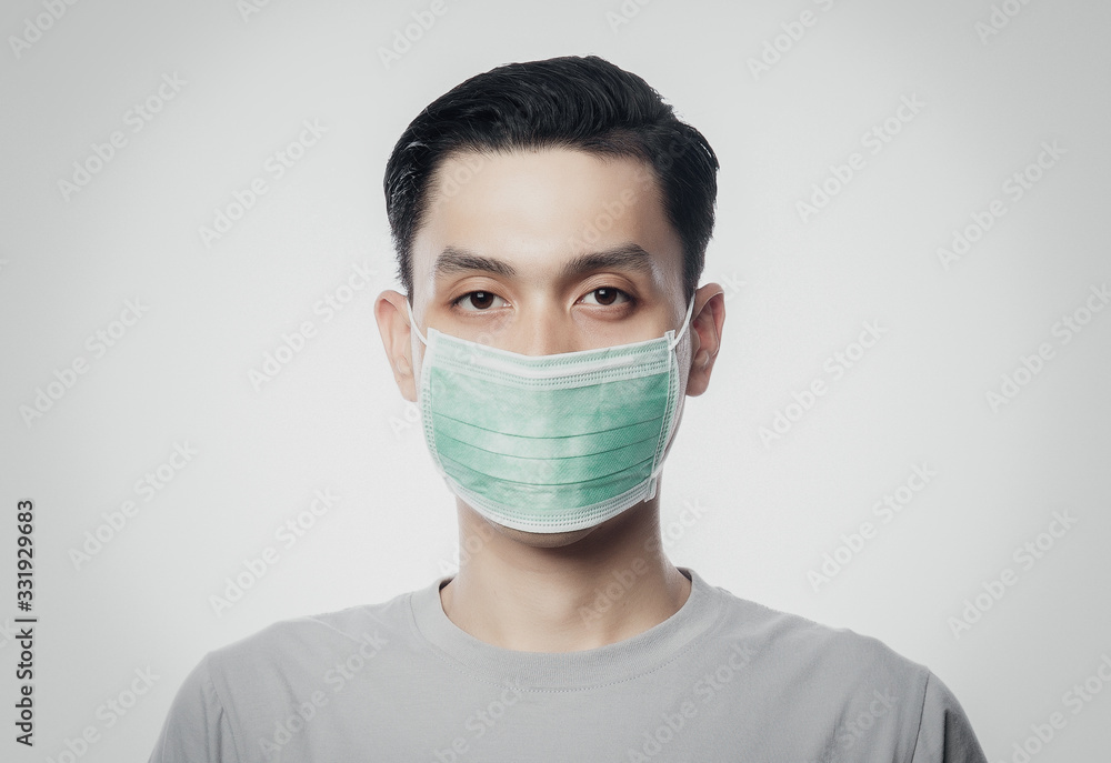 Closeup Young Asian Man wearing hygienic mask to prevent infection, 2019-nCoV or coronavirus. Airborne respiratory illness such as pm 2.5 fighting and flu isolated on white background. Closeup Young Asian Man wearing hygienic mask to prevent infection, 2019-nCoV or coronavirus. Airborne respiratory illness such as pm 2.5 fighting and flu isolated on white background.
