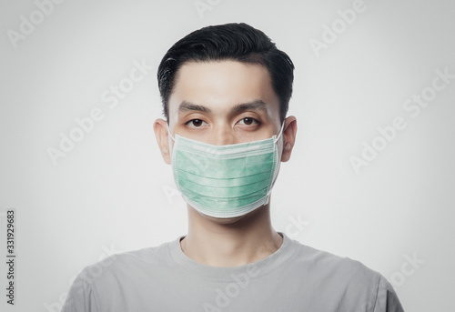 Closeup Young Asian Man wearing hygienic mask to prevent infection, 2019-nCoV or coronavirus. Airborne respiratory illness such as pm 2.5 fighting and flu isolated on white background.