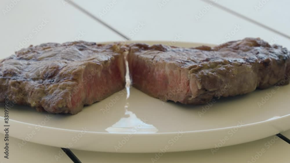 Medium rare beef steak on white plate, close up Medium rare beef steak on white plate, close up