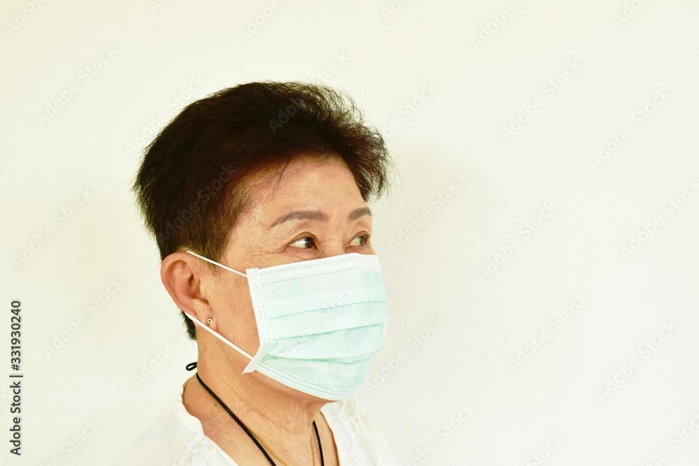 Asian elder woman wearing hygienic mask robe for protection nose and mouth from virus