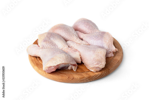 Raw chicken legs on wooden board isolated on white background.