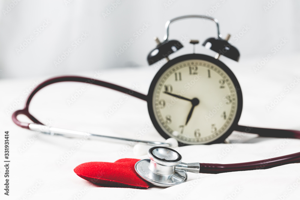red heart with stethoscope and alarm clock close up red heart with stethoscope and alarm clock close up