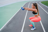 Sports and fitness outside the gym. Young fit woman with perfect body in sportswear trains outdoors on the playground. Sportive and healthy lifestyle, street work out, training, exercise concept.