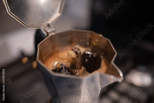 Coffee Moka for Italian espresso. Prepairing breakfast drink. Caffeine aroma. Closeup Traditional moka at home. Coffee splashing photo