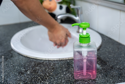Man washes his hands with liquid soap in the sink