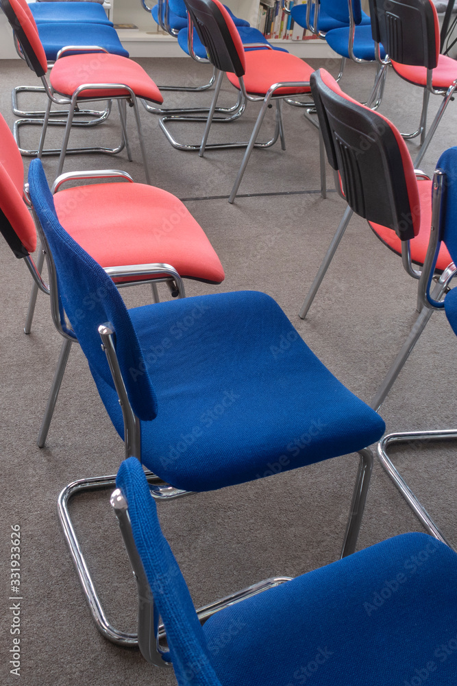 Chairs red and blue in a meeting room. Empty seats in auditorium. Selective focus.