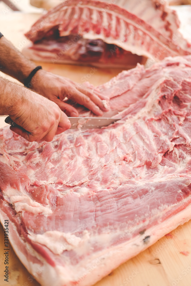 cutting raw meat. hands and knife. cuts of pork