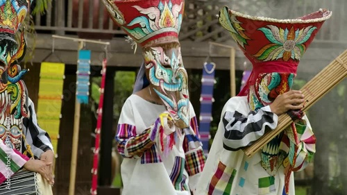 The  people in Thailand on phitakhon ghost festival holiday carnival wearing colorful custume clothes wearing hand paint mask dancing on street with happiness.   photo