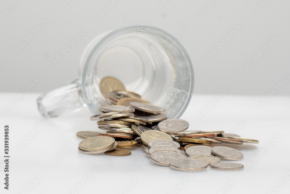 trifle Russian coins pouring from a glass jar on a white background, concept of low-denomination coins, saving, selective focus trifle Russian coins pouring from a glass jar on a white background, concept of low-denomination coins, saving, selective focus