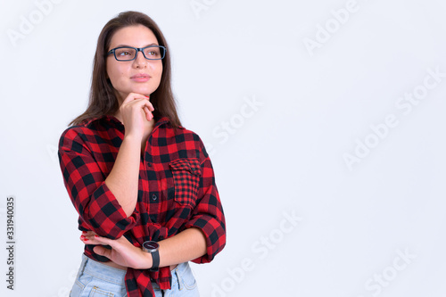 Portrait of young beautiful hipster woman thinking and looking up