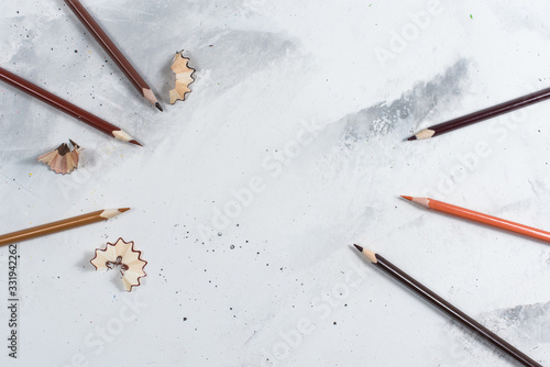 Brown pencils on a white stone table