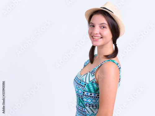 Profile view of happy young beautiful tourist woman looking at camera